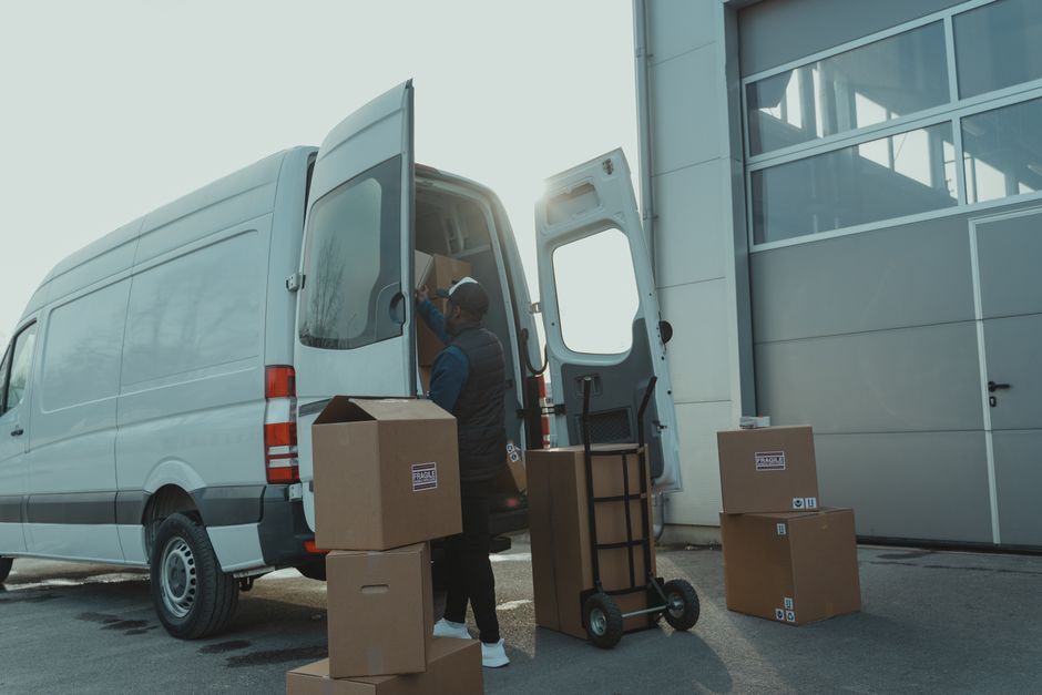 A crew member loading boxes into a van, illustrating how a house clearance collection works